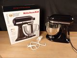 a black kitchenaid mixer and a pair of scissors on a table
