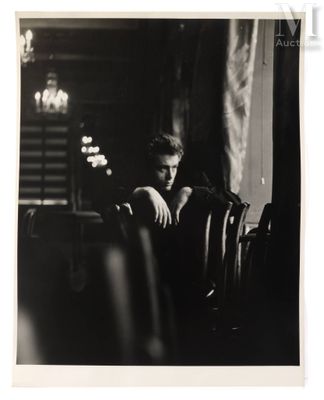 photographie en noir et blanc d'un homme assis à une table