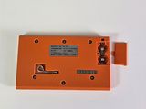 an orange electronic device sitting on top of a white surface