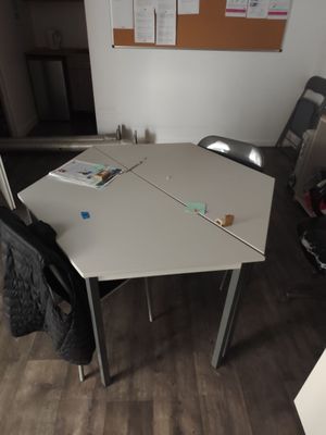 une table blanche avec une chaise noire dans une pièce