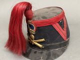 a small hat with a red hair and a doll sitting on it