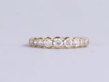 an image of a gold ring with five round diamonds