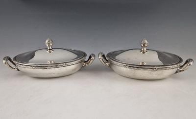 a pair of silver plated dishes with handles and handles