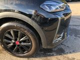 a close up of a black car with a red emblem on it