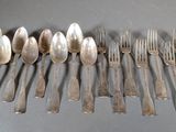 many forks and spoons laid out on a table