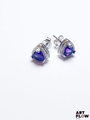 gros plan d'une paire de boucles d'oreilles sur une surface blanche
