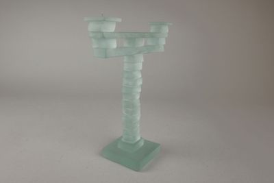un bougeoir en verre posé sur une table, sur fond blanc