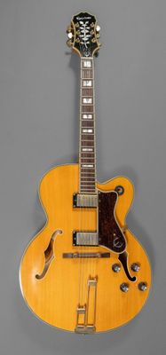 un gros plan d'une guitare jaune sur fond gris