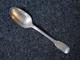 a spoon that is laying on a black surface