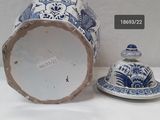 a blue and white vase with a lid next to it