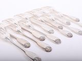 six silverware spoons and a fork on a white surface