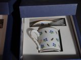 a coffee cup and spoon in a box on a table