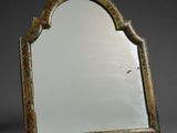 un vieux miroir orné d'un motif décoratif dans sa partie supérieure