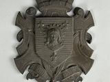 a metal plaque with a coat of arms and a crown on it
