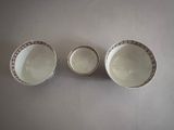 three white and brown bowls sitting on top of a white table
