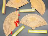 four chinese fans and a ruler on a table