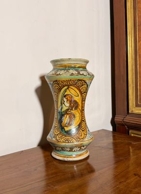 un vase posé sur une table en bois devant un tableau
