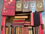 an open box of old books sitting on top of a table
