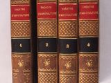 trois vieux livres sont alignés sur une surface blanche