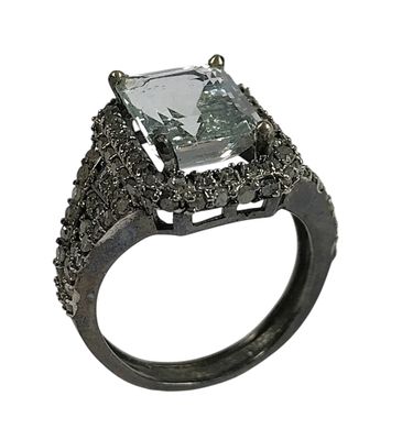 une image représentant une bague raffinée ornée d'une pierre verte entourée de diamants noirs