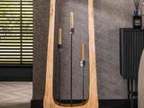 a wooden floor lamp that is next to a bed