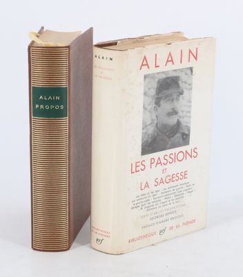 un vieux livre posé à côté d'un livre encore plus ancien sur une surface blanche