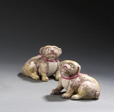 paire de figurines en céramique représentant deux chiens assis sur une surface grise