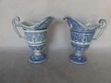 two blue and white vases sitting next to each other