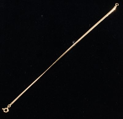 an image of a gold necklace on a black background