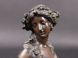 bronze statue of a woman with flowers in her hair