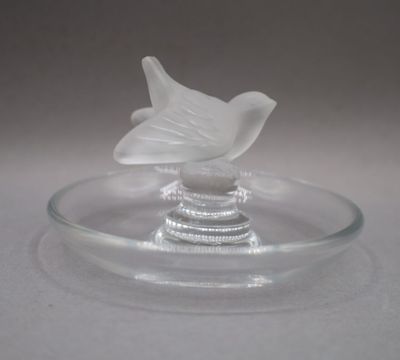 une plaque de verre sur laquelle est représenté un oiseau, posée sur une table