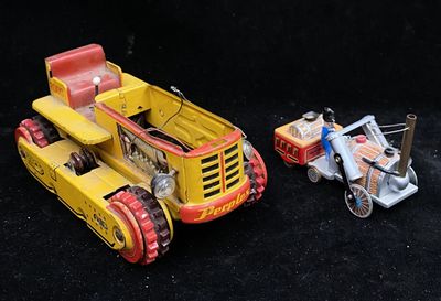 two toy vehicles that are sitting next to each other on a black surface