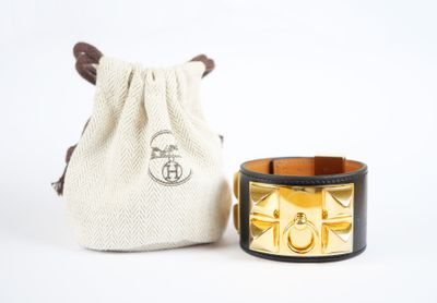 un bracelet noir et doré orné d'un manchettes dorée