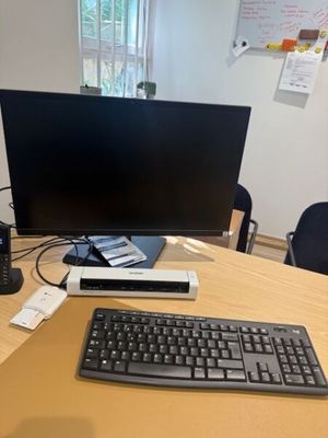 a computer desk with a keyboard, mouse, and monitor