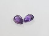 a pair of purple amethtites sitting on top of a white surface
