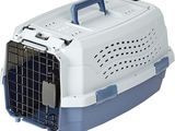 un gros plan d'une cage de transport pour chien dont la porte est ouverte