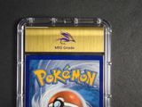 the pokemon card is in a plastic case on a black surface
