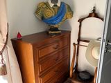 une statue représentant un homme posée sur une commode dans une pièce