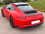the rear end of a red porsche 911 gts parked in a parking lot