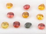 un ensemble de pierres précieuses de différentes couleurs posées sur une surface blanche