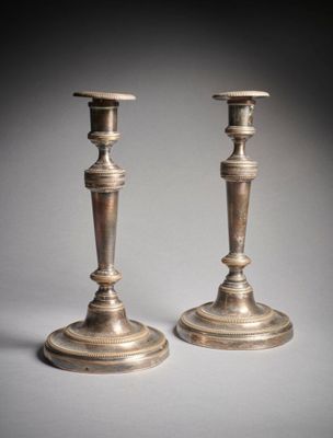une paire de bougeoirs anciens en argent sur fond gris