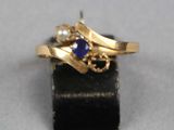 une image représentant une bague en or sertie d'un saphir et de perles