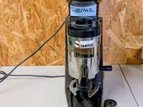 a coffee grinder sitting on a counter next to some spoons