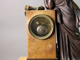 a statue of a woman leaning on a clock