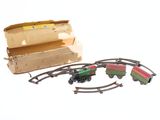 un petit train miniature posé sur les rails à côté d'une boîte en carton