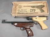 un vieux pistolet et un paquet de cigarettes posés sur une table