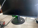 un écran d'ordinateur posé sur une table en bois