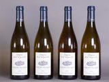 four bottles of wine are lined up on a table