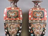 une paire de vases posés sur un socle en bois, sur une surface grise