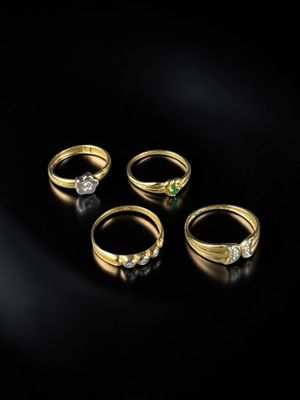 un ensemble de cinq bagues en or serties de diamants sur fond noir